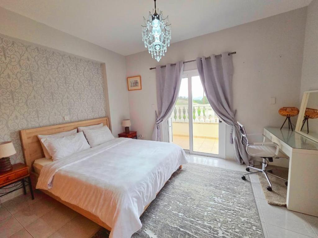 a bedroom with a bed and a desk and a chandelier at Letymvou Terrace in Letimbou