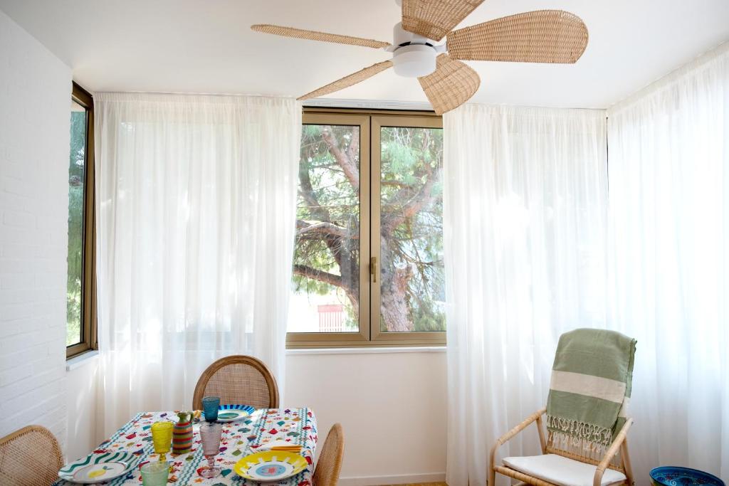 a dining room with a table and a ceiling fan at Appartamento l'Isola D'Oro in Grado