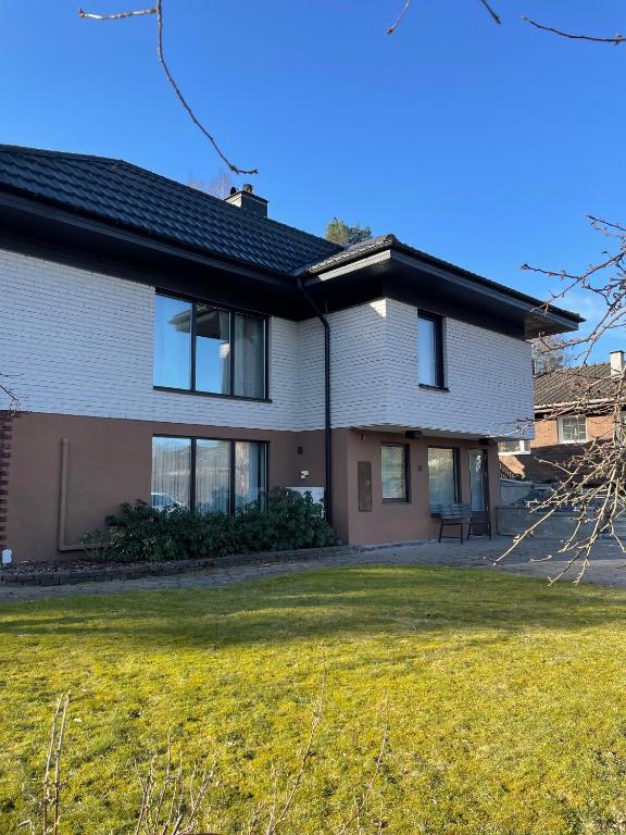 a house with a lawn in front of it at Fully equipped guest apartment with parking in Upplands-Väsby