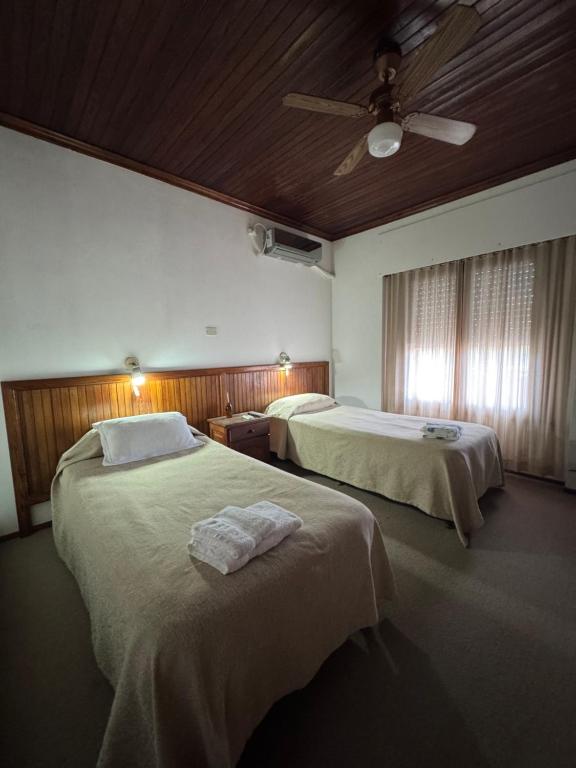 a bedroom with two beds and a ceiling fan at Hotel Guamini in Guaminí
