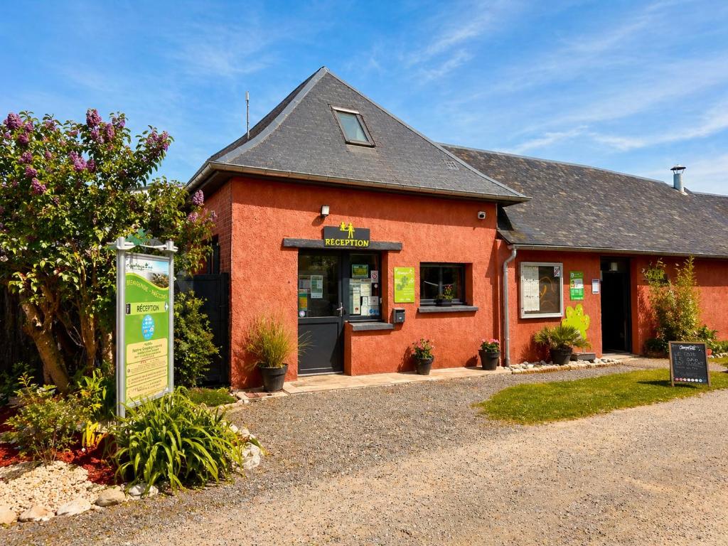 a red building with a sign in front of it at Camping de la Baie-Baie de Somme-Sites et Paysages in Pendé