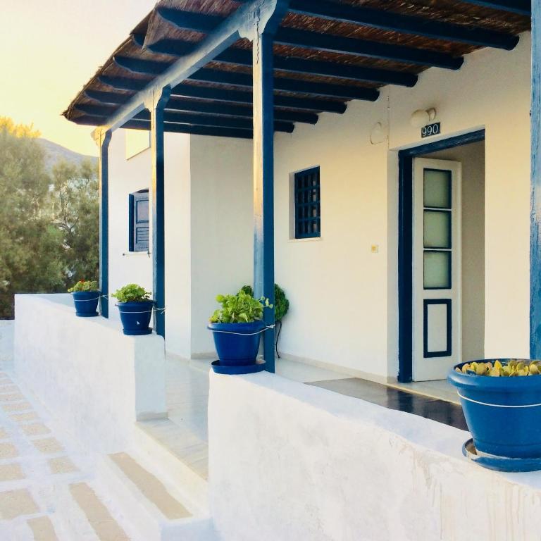 a porch with blue potted plants on it at Andromeda in Ios Chora