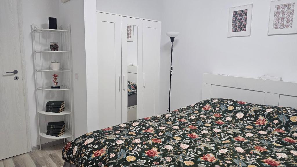 a bedroom with a bed with a floral bedspread at Modern Family Apartment, Free Parking, Balcony, Sleeps 5 in Bucharest