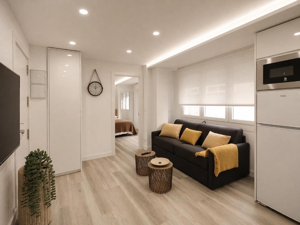 a living room with a couch and a kitchen at Sisargas Playa in Malpica