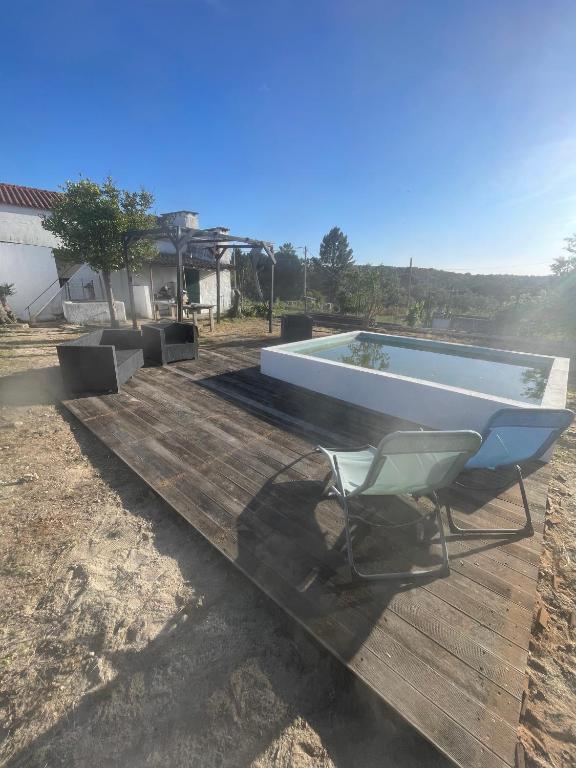 a chair sitting on a deck next to a swimming pool at Casa da Barragem Montargil in Montargil