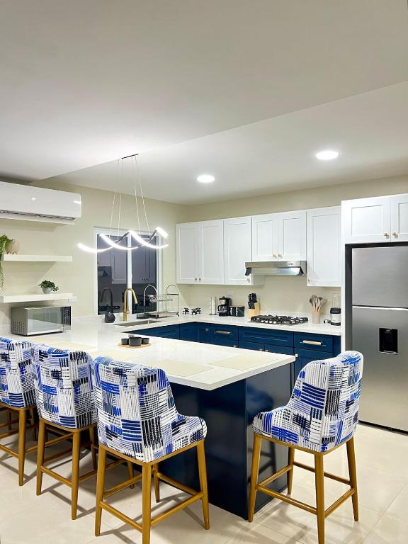 a kitchen with blue and white cabinets and a table and chairs at Rest and Reset in Usulután