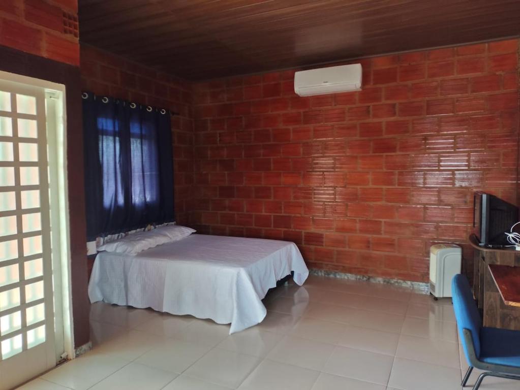 a room with a bed in a brick wall at Kitnet Rústica! in Januária