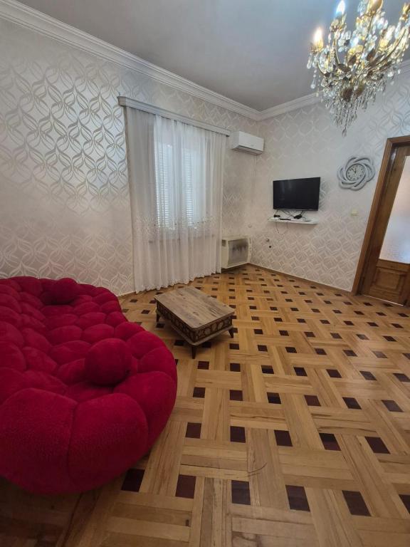 a living room with a red couch and a television at Milo Comfort 2 in Rustavi