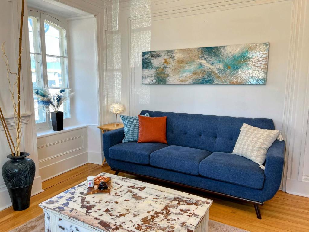 a blue couch in a living room with a table at Maison meublée et équipée, clé en main pour séjours 31 jours et plus! in Quebec City