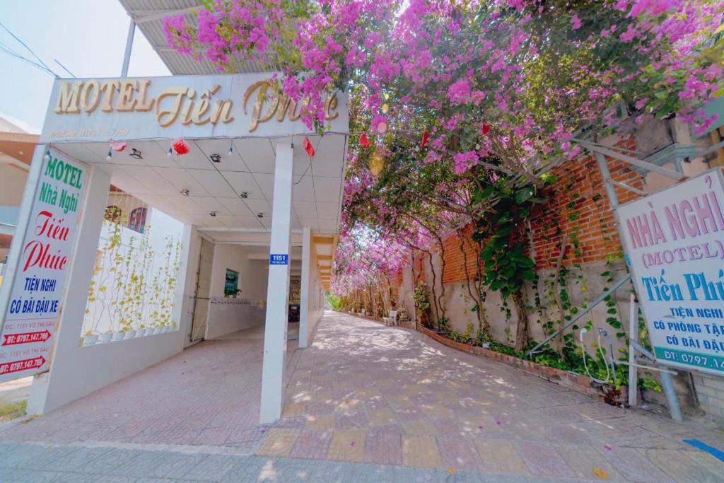 a building with a tree with pink flowers on it at Motel Tiến Phúc in Long Hai