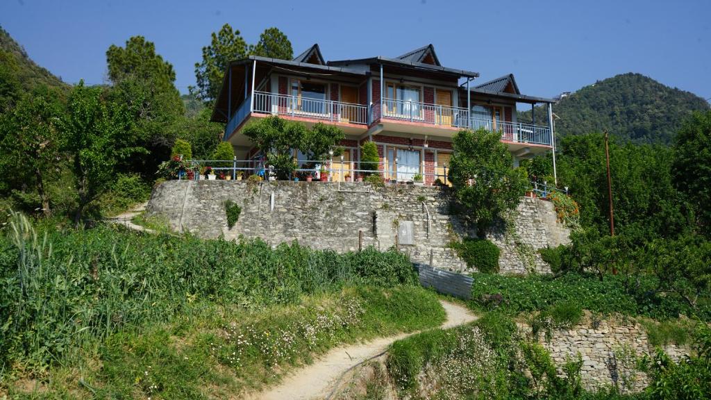 a house on top of a stone wall at Saanidhya Homestay in Mukteshwar