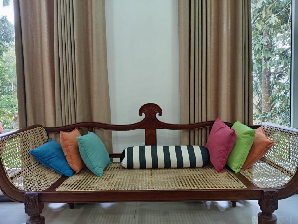 a bench with colorful pillows on it in a room at Misty Edge Hanthana in Kandy