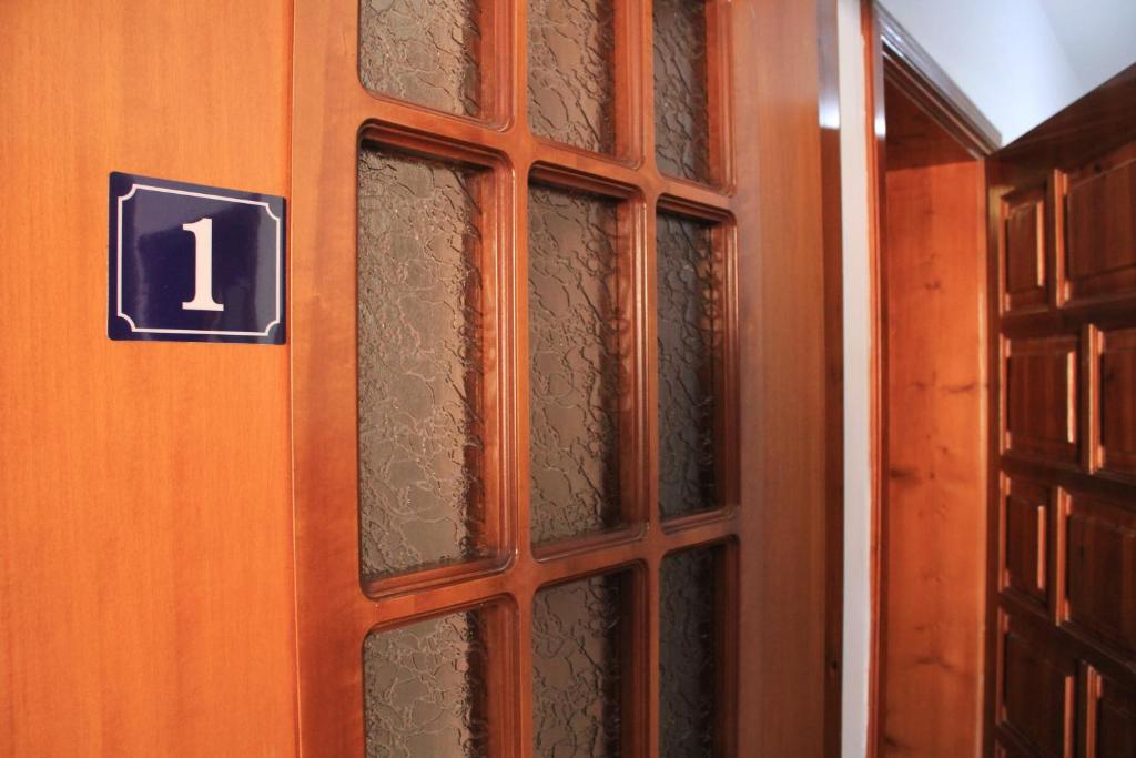 a wooden door with glass panels with the number one at Casa Elefteria & Viron in Himare