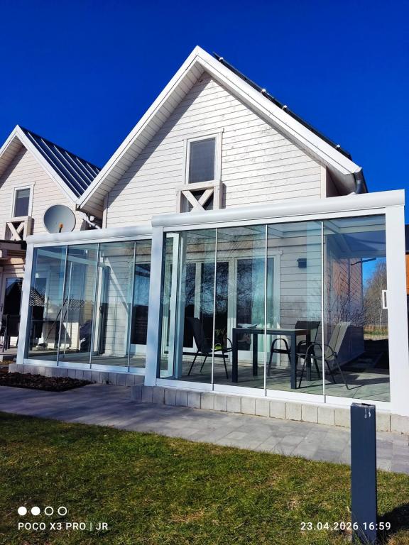 a house with glass doors and a table in it at Baltic Rafa in Niechorze