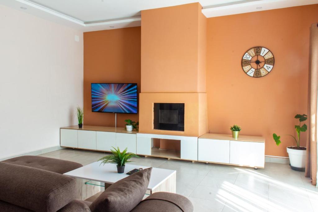 a living room with orange walls and a tv at confortable calme , wifi gratuit in Antananarivo