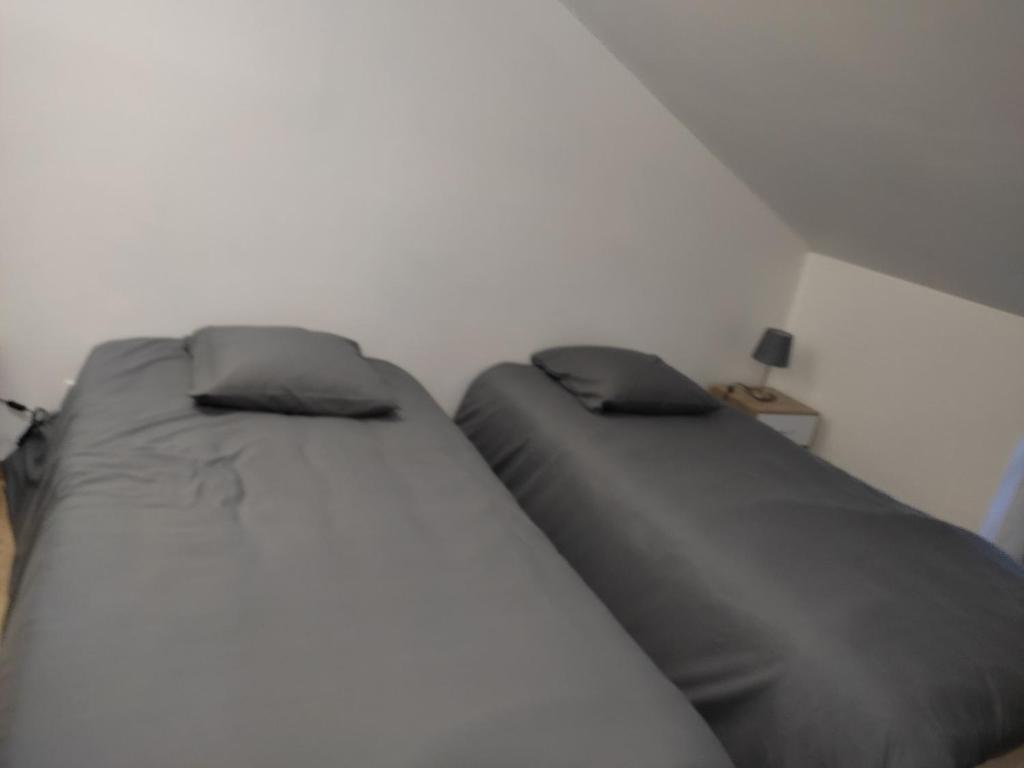 two beds sitting next to each other in a room at chemin de compostelle in Montcuq