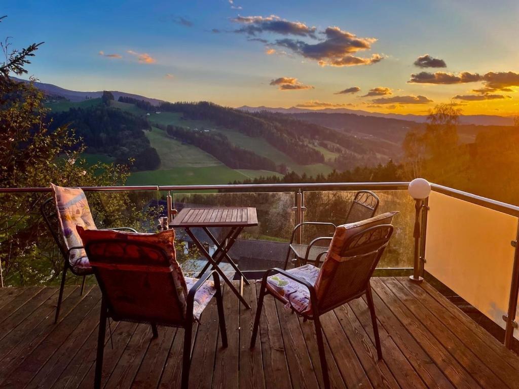 a table and chairs on a deck with a view at Chalet am Sonnberg in Kleinlobming