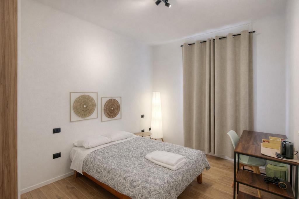 a white bedroom with a bed and a desk at Affittacamere Villa Soria in Pesaro