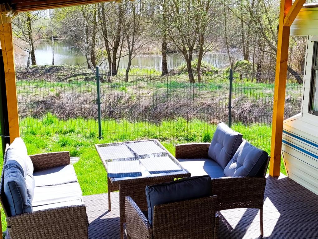 a patio with a table and chairs and a view of a field at Nad Łabędzim Stawem in Dratów