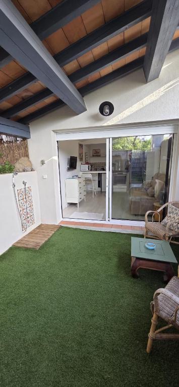 a living room with green carpet and a patio at Studio indépendant 2 personnes in Le Pradet