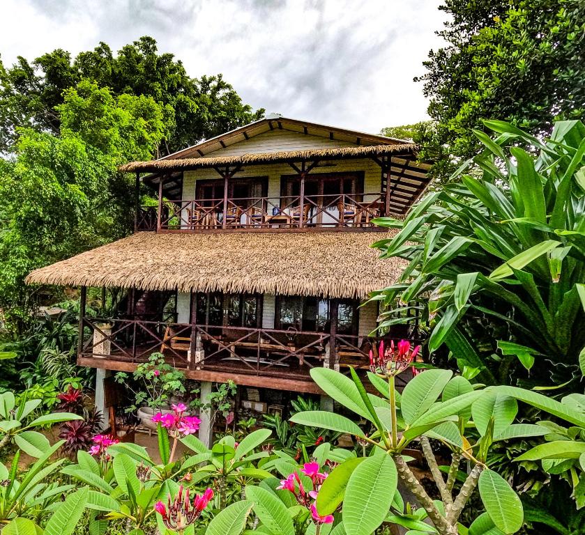 a house with a deck with chairs and flowers at Red Frog Bungalows Ocean Resort in Short Cut