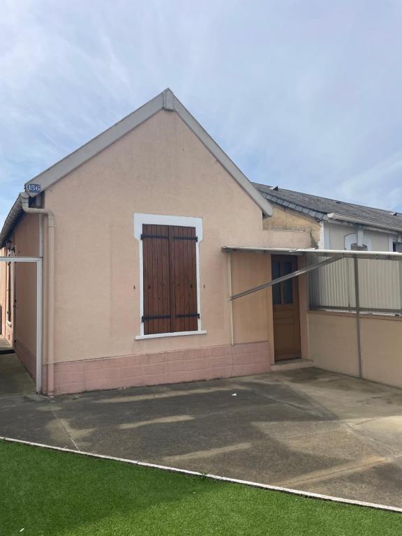 a house with a garage and a fence at Maison charmante in Le Mans