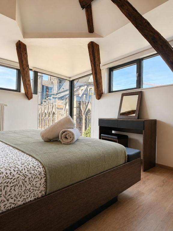 a bedroom with a bed and a desk and windows at Historic Centre Duplex - Ghent Belfry & St Nicholas Church View in Ghent