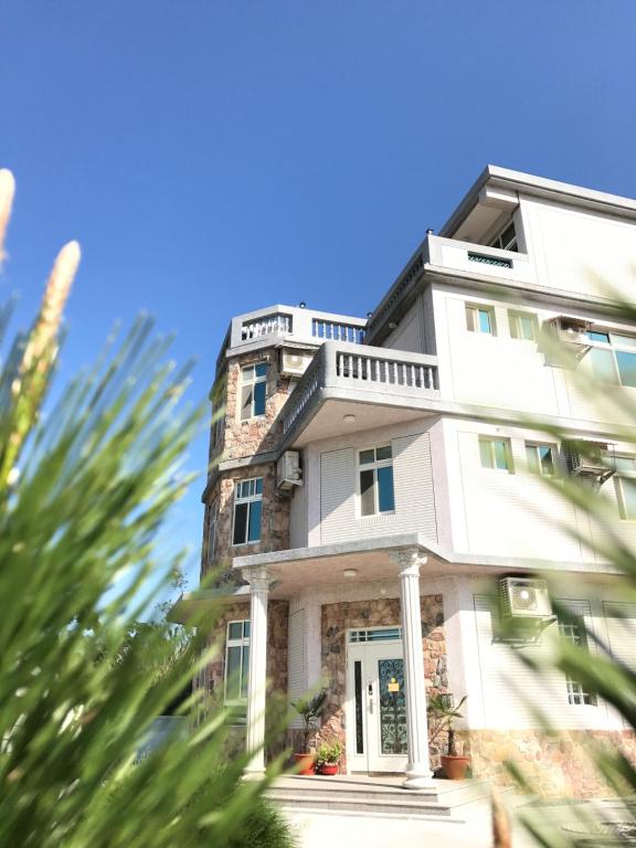 a tall white building with a front door at Little Weekend Inn in Jincheng