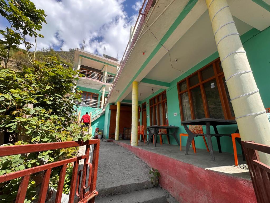 a building with a porch with a table and chairs at Blue Heaven Tosh in Tosh