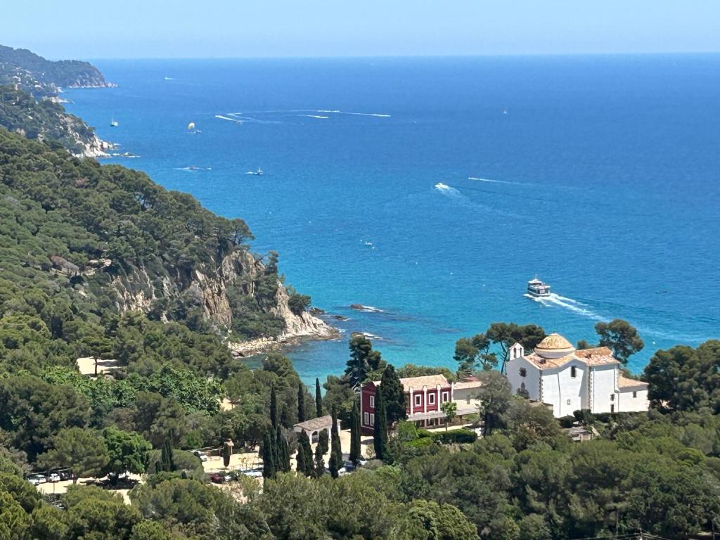 a house on a hill next to the ocean at Villa La Gavina Sea View Pool and Beaches in Blanes