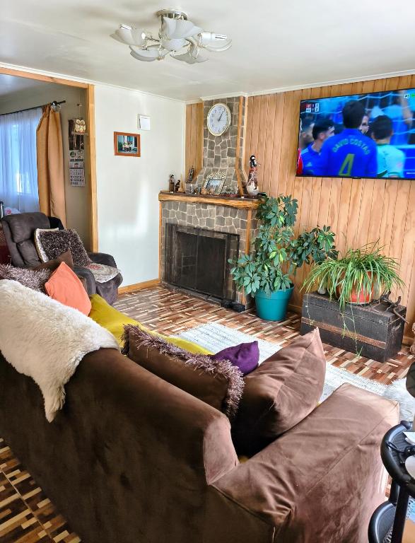 a living room with a couch and a fireplace at Donde Mauricio in Coihaique