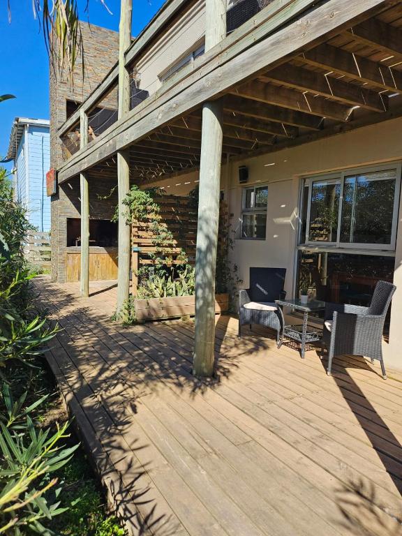a wooden deck with chairs and a table on a house at MarEz in Punta Del Diablo