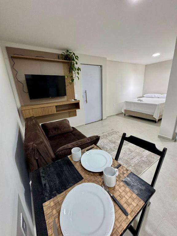 a living room with a table and a couch at No centro, em frente à praça in Eunápolis