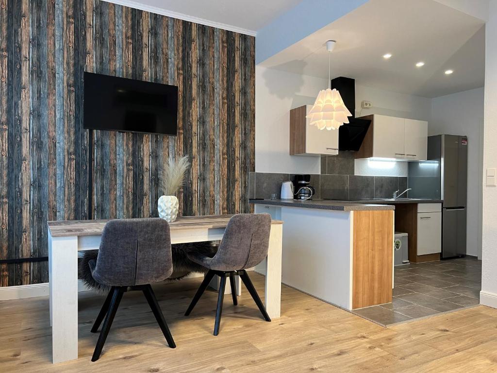a kitchen with a wooden table and two chairs at Nahe Schlosspark Husum in Husum