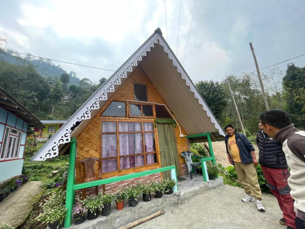 two men standing in front of a small house at Golays homestay in Kalimpong