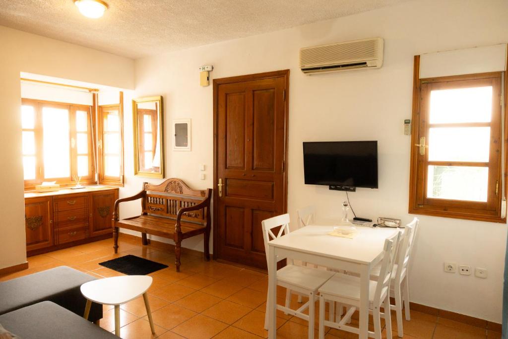 a living room with a white table and a television at SteMaMaisonette in Afantou
