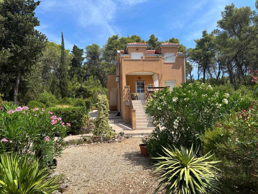 a house in the middle of a garden at Apartmani Lada 2 in Vrboska