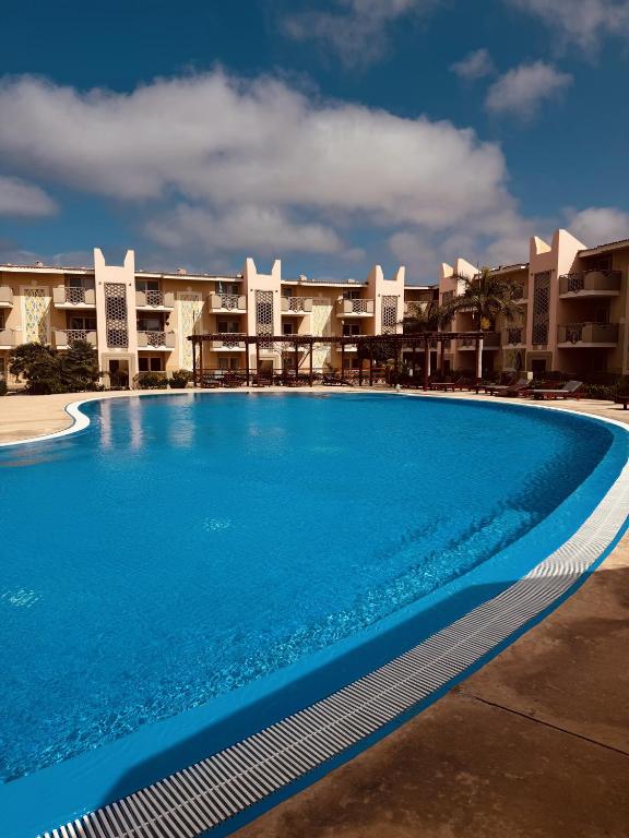 a large swimming pool in front of a building at Tropisal Apartamento in Santa Maria