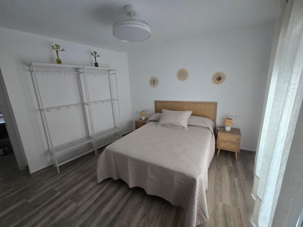 a bedroom with a bed with a white bedspread at Casa Alba del Cabo in Los Albaricoques