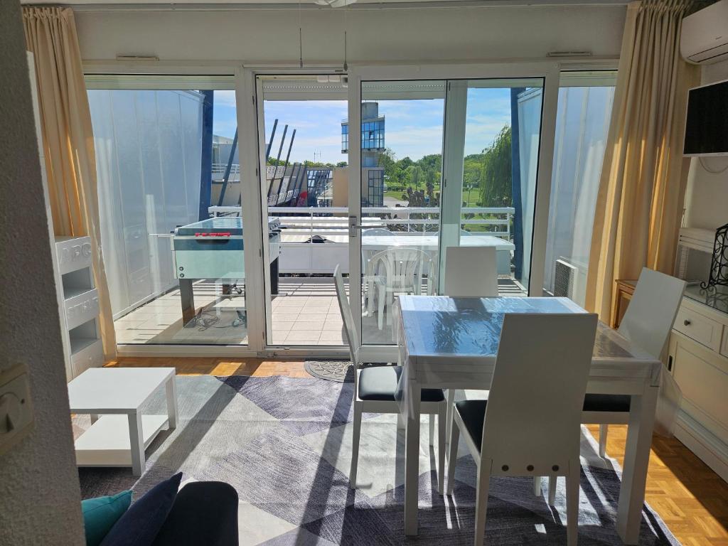 a dining room with a table and chairs and a balcony at Port Dienville in Montfort-lʼAmaury