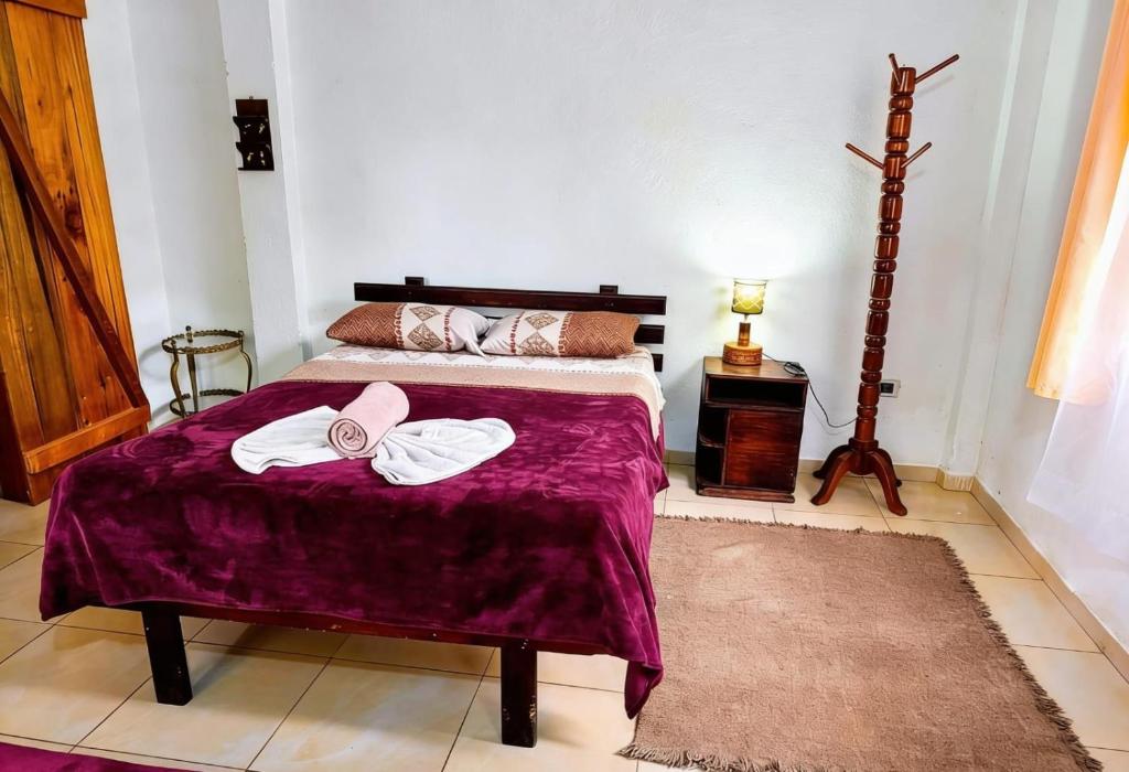ein Schlafzimmer mit einem Bett, auf dem zwei Handtücher liegen in der Unterkunft Mindomundo Home in Mindo