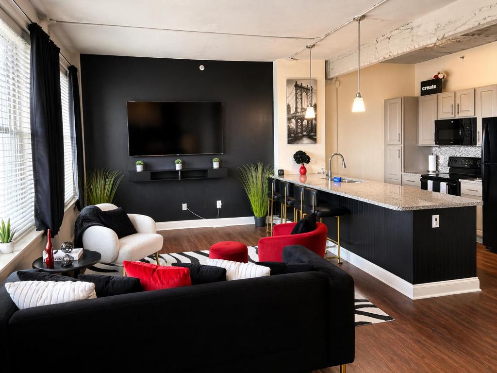 ein Wohnzimmer mit schwarzem Sofa und roten Kissen in der Unterkunft EMLuxe in Memphis