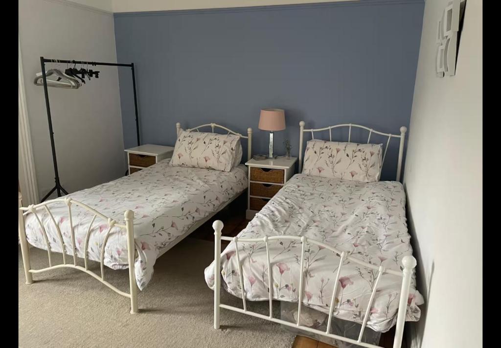 ein Schlafzimmer mit zwei Betten und einer Lampe in der Unterkunft Faversham cottage in Kent