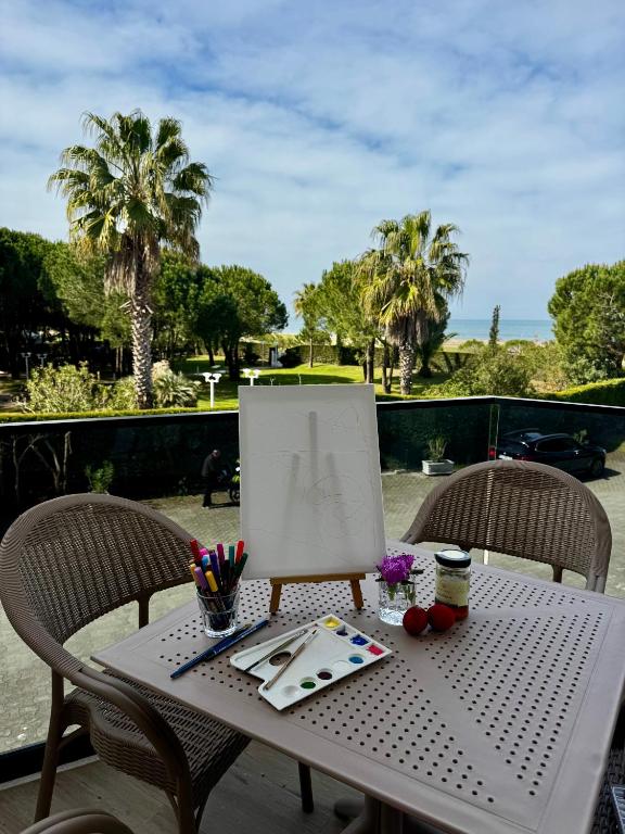 a table with a painting on it with two chairs at Villa Fibonacci - Beachfront Lalez Bay Durres in Draç