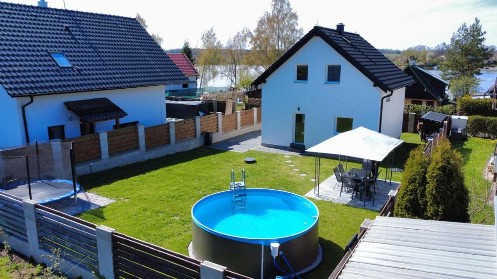 a backyard with a hot tub and a house at Vila Jesenice in Lipová