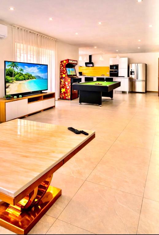 a large living room with a large flat screen tv at Villa 220 m2 avec 5 chambres 6 lits doubles 2 toilettes 2 salles de bain in Beire-le-Châtel