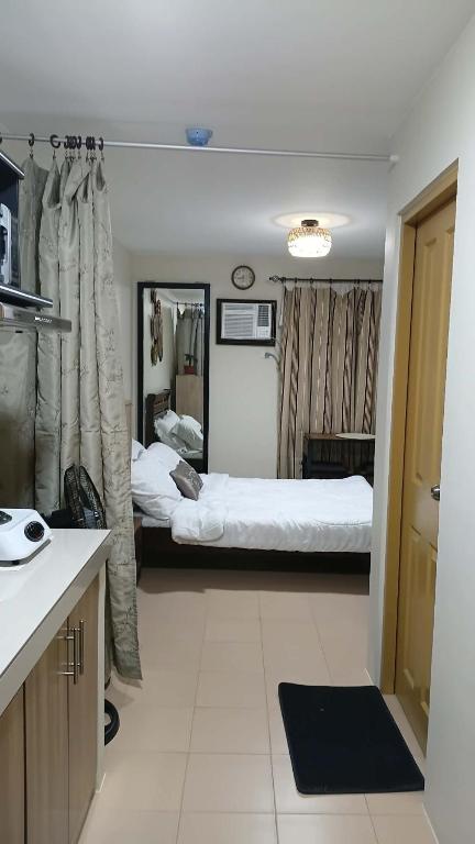 a bedroom with two beds and a kitchen with a sink at Keyspace condotel in Piapi