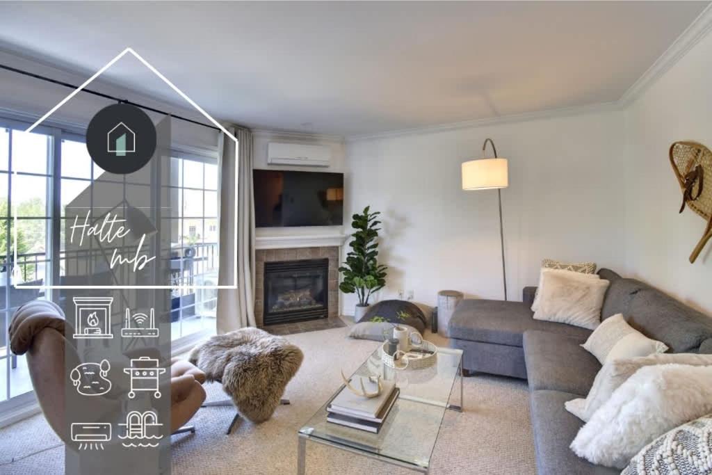 a living room with a couch and a fireplace at La Halte Mont-Blanc Ski in out in Saint-Faustin