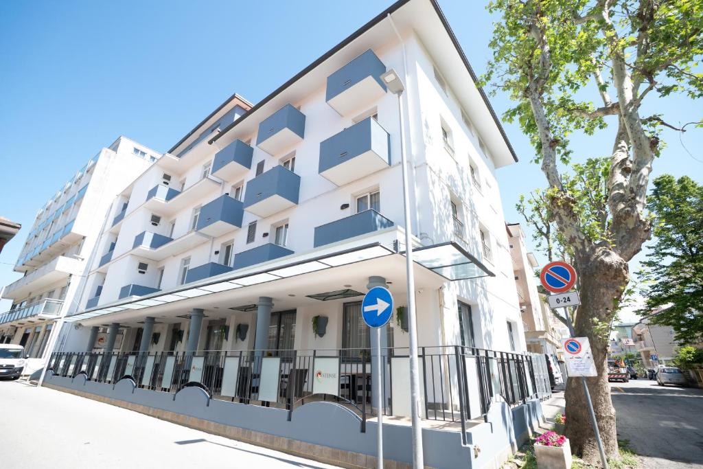 a white building on the side of a street at Hotel Estense in Bellaria-Igea Marina