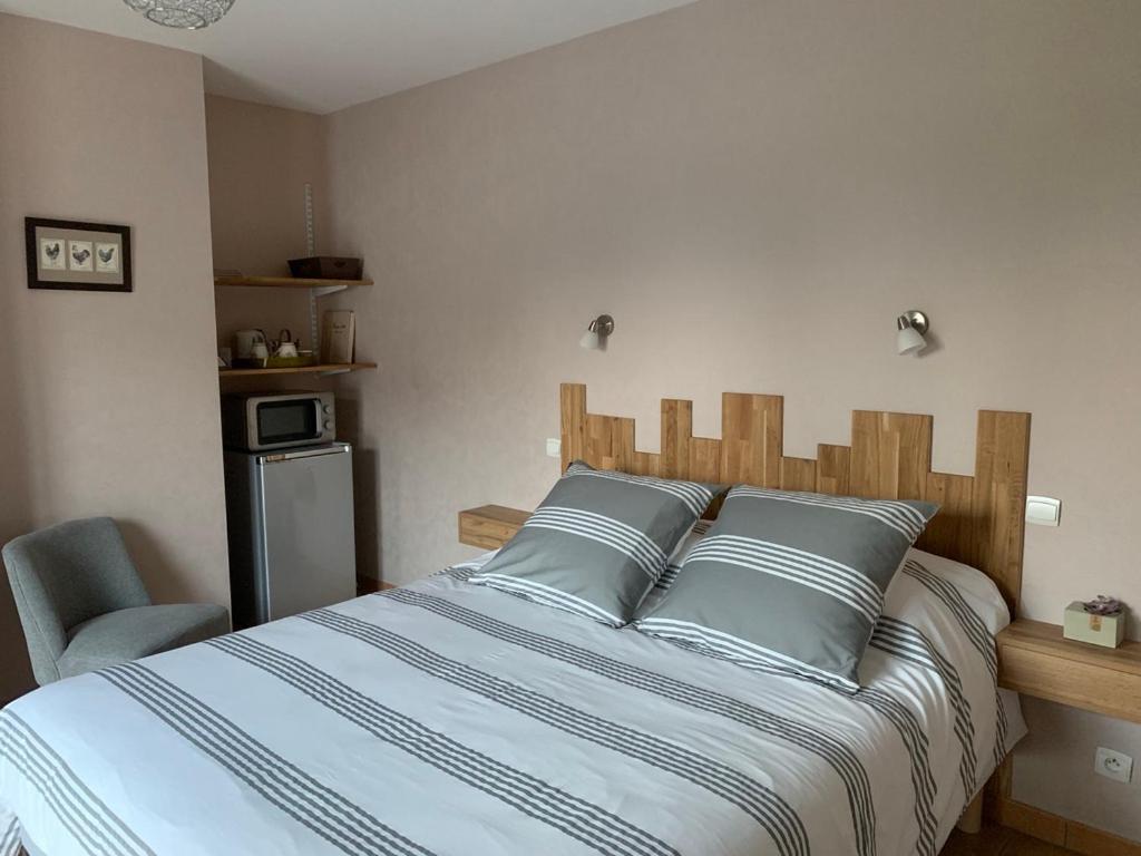 a bed with blue pillows in a bedroom at La brèche fleurie in Cricquebœuf